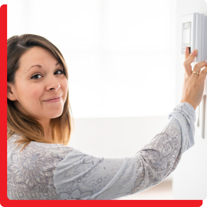 a woman adjusting the thermostat
